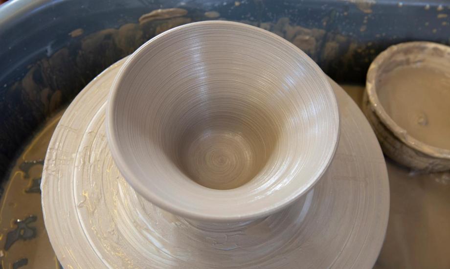 Close up image of a clay bowl on a potters wheel